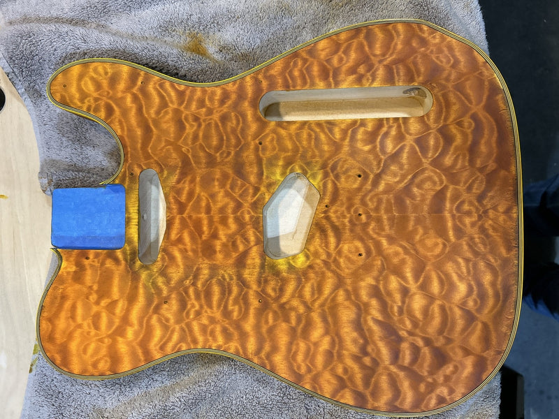 Quilted maple T-style DIY guitar body with an amber hand-rubbed finish, built by community member Steve