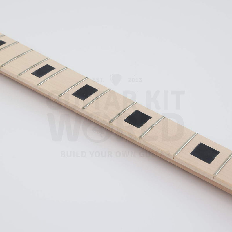 Close-up of black block inlays on the maple bass fretboard