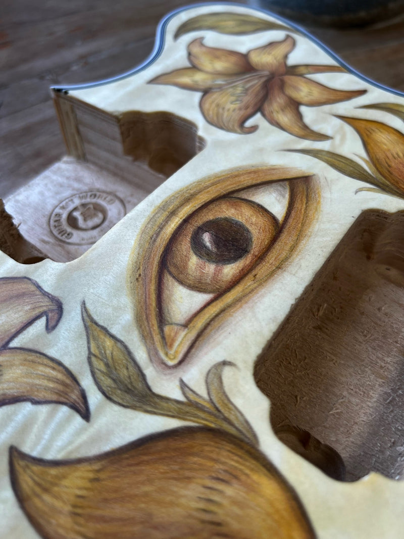 Close-up of the drawn eye next to a routed pickup cavity with a stamp in the wood