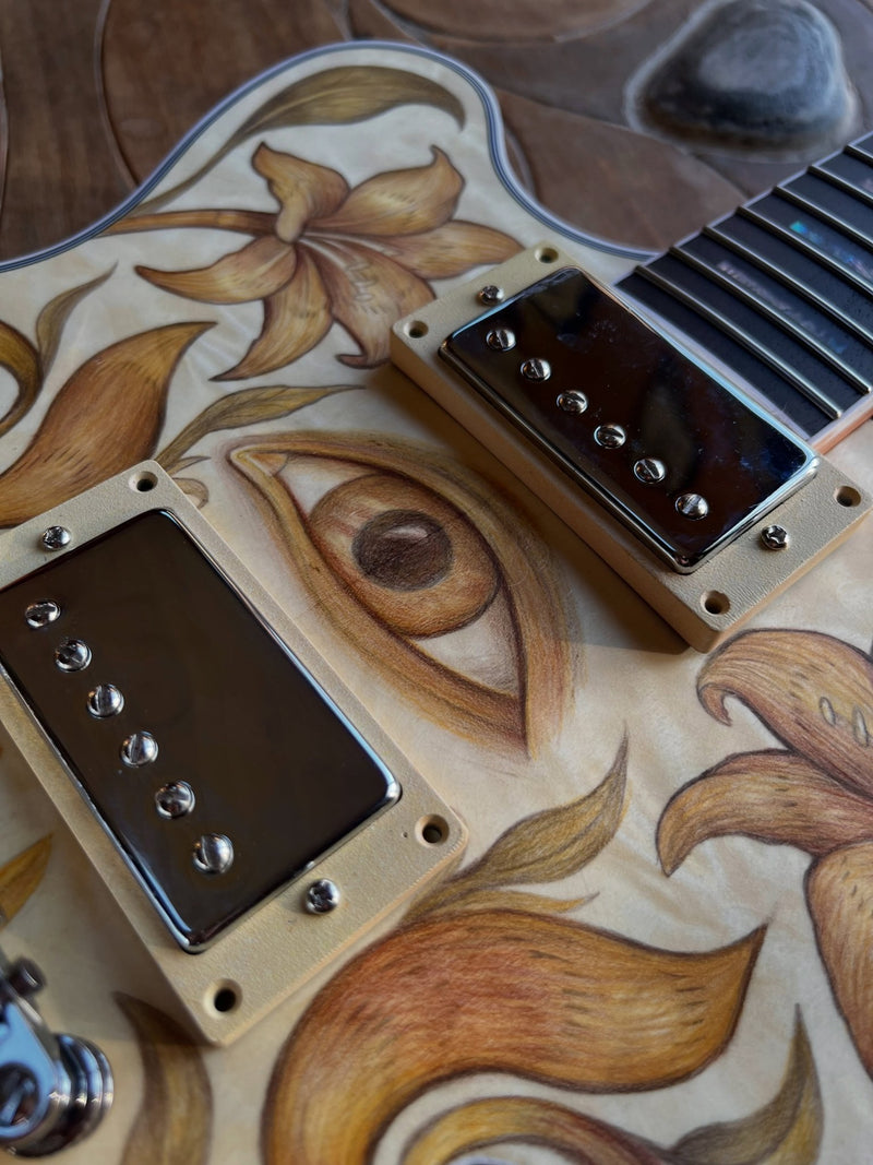 The drawn eye positioned between the two humbucker pickups