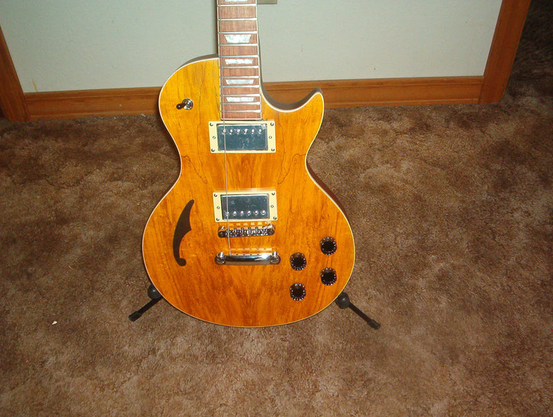 Amber single-cutaway guitar with an f-hole and two humbuckers, built by Byron in 2012