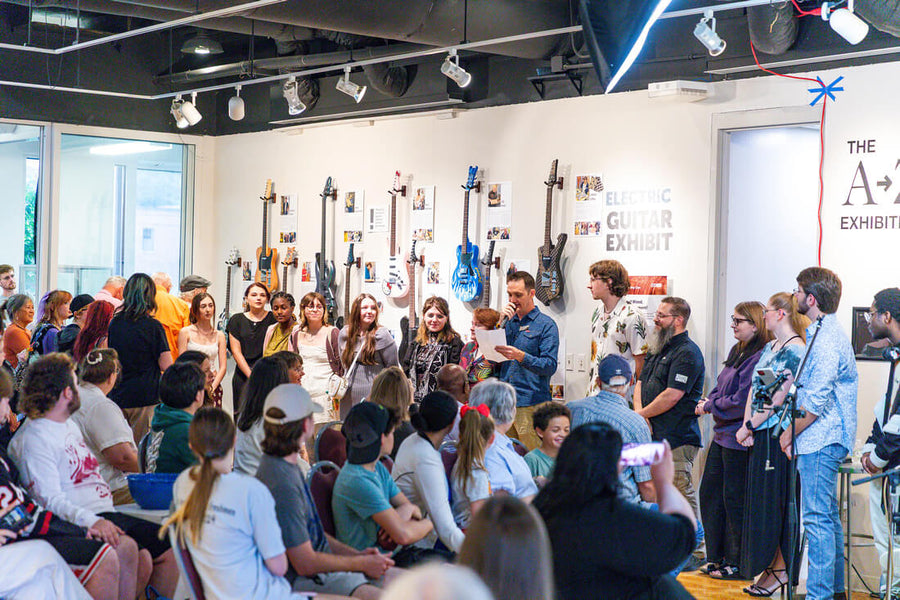 Faculty and students gather at the Electric Guitar Exhibit, showcasing unique instruments built during SAU’s guitar-building program.