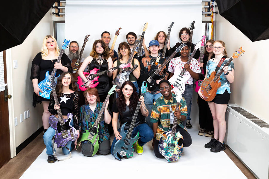 A group of Southern Arkansas University students proudly display the custom electric guitars they designed, built, and finished in class.