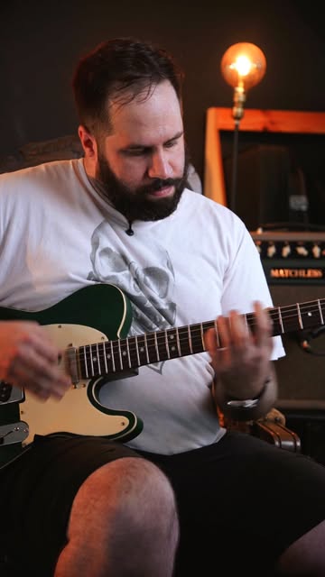 A tocar a guitarra elétrica verde terminada na Clínica da Guitarra