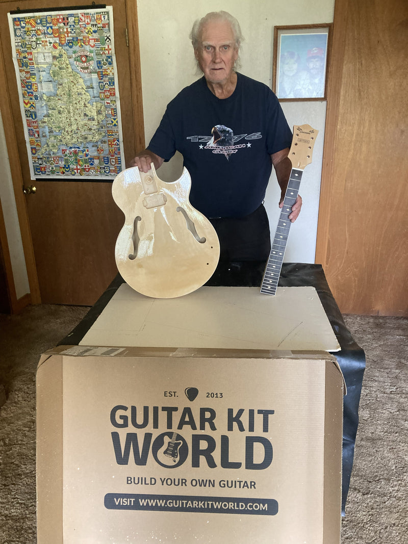 Byron Stafford holding the unfinished body and neck of his newest hollow body guitar kit