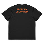 Black Properly Grounded Heavyweight Tee, orange Guitar Kit World logo, back view with PROPERLY GROUNDED. across the upper back
