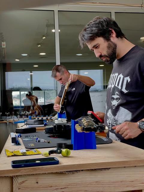Dois formandos a trabalhar em braços de guitarra nas bancadas da Academia Clínica da Guitarra, em Pombal