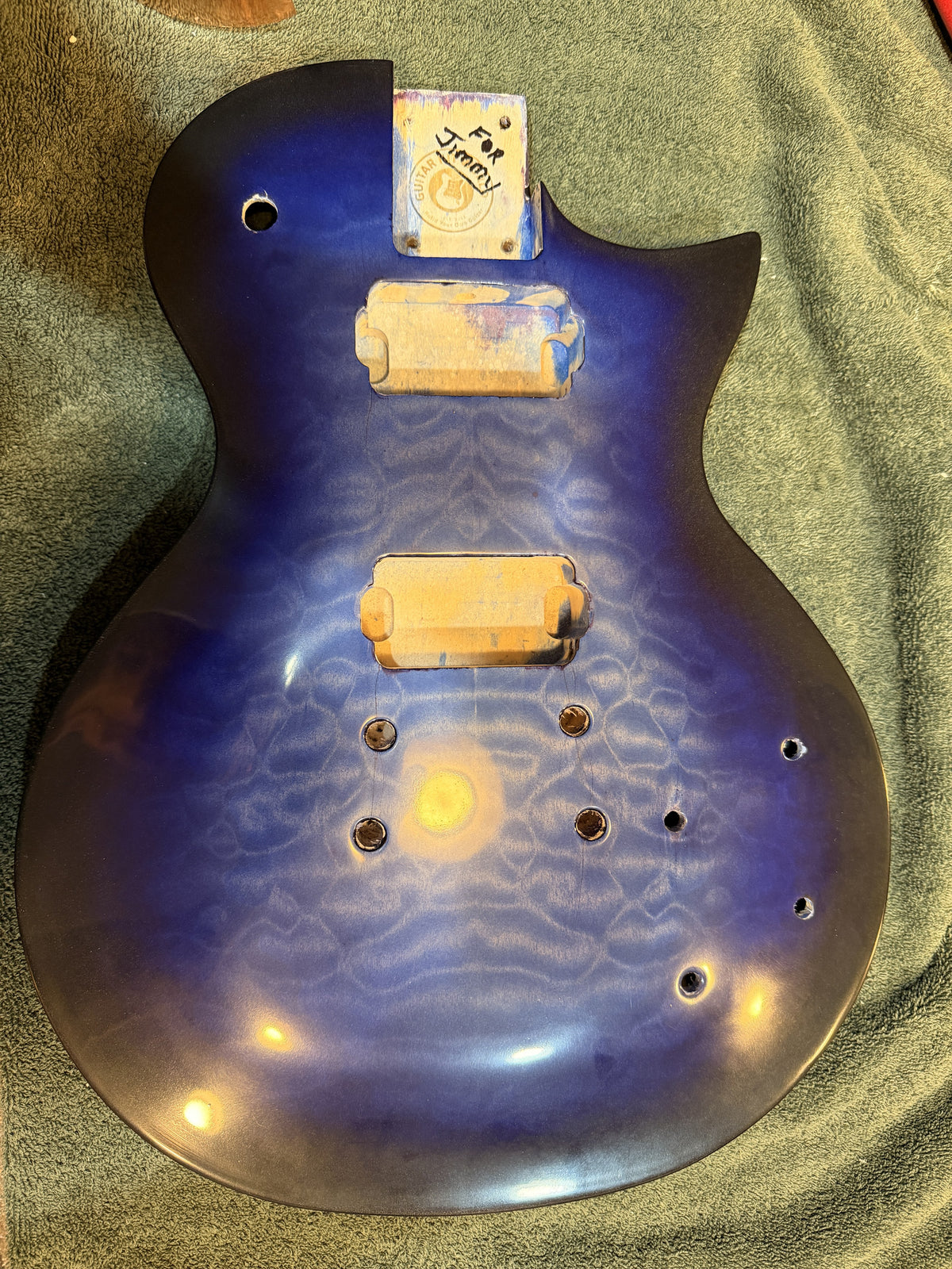 Blue burst guitar body after clear coat with the pickup cavities and neck pocket still masked off