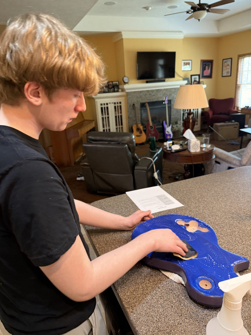 Hand sanding the blue dyed veneer top on a kitchen counter