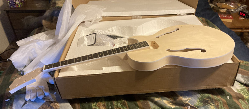 Archtop guitar kit neck and body laid out side by side on top of the shipping box