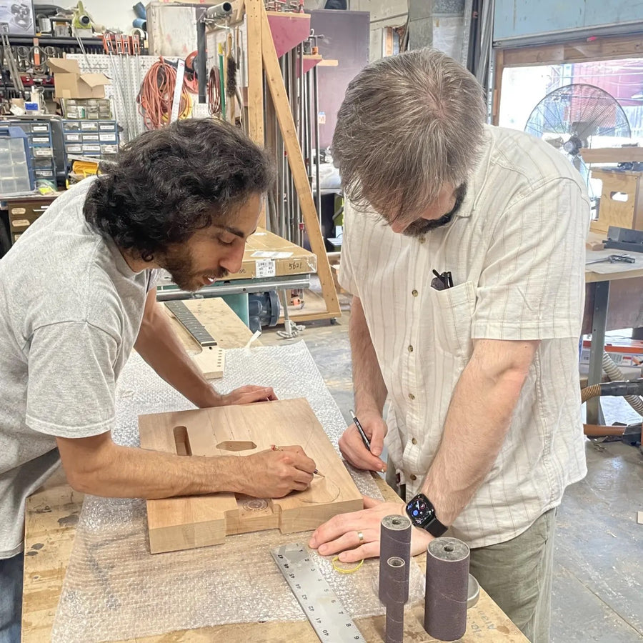 Luthier and student marking out a guitar body on the bench at the Baltimore guitar building workshop
