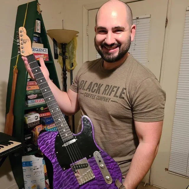 Lucas Payne holding a purple quilted-maple T-style guitar he built as a gift for his dad
