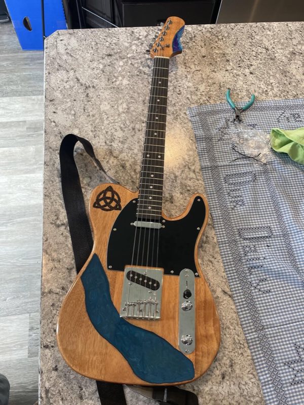 Guitar body with a blue epoxy river poured into it